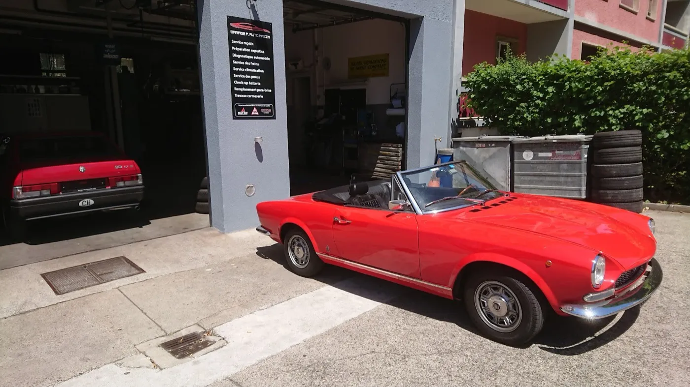 Un spider italien classique rouge devant l'atelier